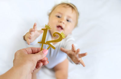 Cropped hand mother holding numbers in front of baby