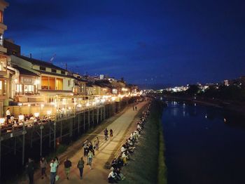 High angle view of people on street amidst buildings at night