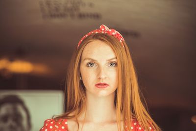 Portrait of beautiful young woman standing against wall