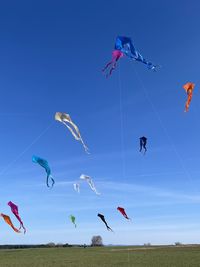 Low angle view of kites flying in sky