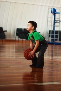 Boy playing with ball in court