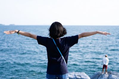 Rear view of woman looking at sea against clear sky