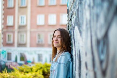 Portrait of woman standing against building