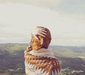 Rear view of woman looking at mountain range against sky