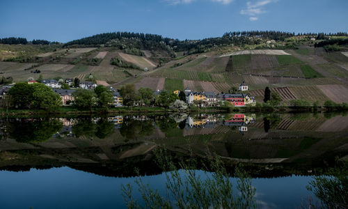 Scenic view of lake by buildings against sky