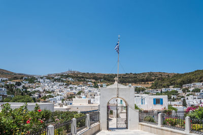 Street amidst buildings against clear blue sky