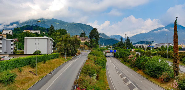 Road by mountains against sky