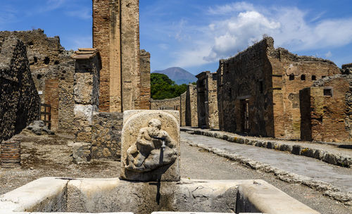 Street photography in ancient  pompeii, public fountain with hercules that kills the lion 