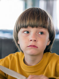 Close-up of boy looking away while sitting at cafe