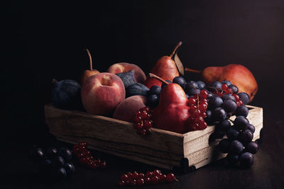 Close-up of grapes on table against black background