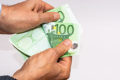 Midsection of man holding paper against white background