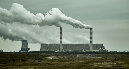 Smoke emitting from chimney against sky