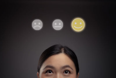 Portrait of woman against illuminated gray background