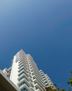 Low angle view of modern building against clear blue sky