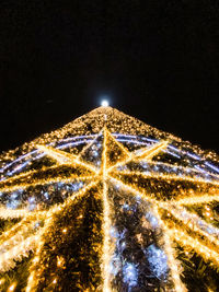 Low angle view of illuminated christmas tree against sky at night