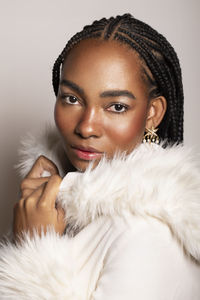 Portrait of young woman against white background