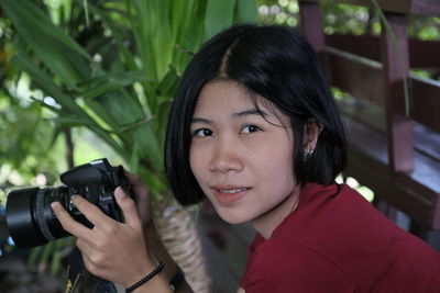 Portrait of smiling woman holding camera