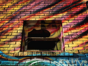 Low angle view of graffiti on brick wall of building