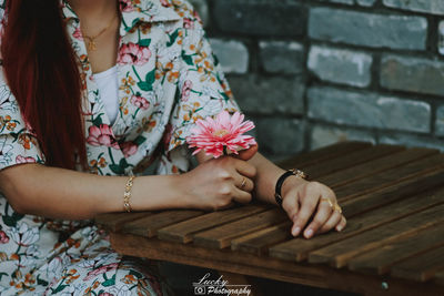 Midsection of woman sitting on footpath