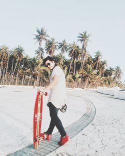 Full length of child on palm tree against sky