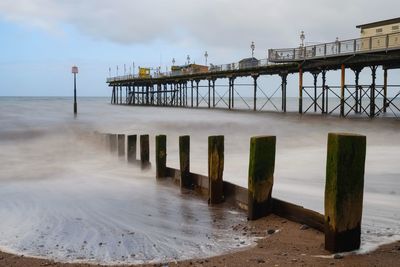 Wooden pier on sea against sky