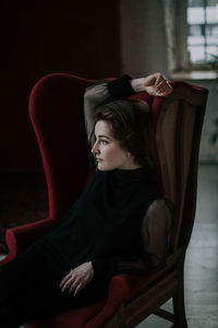 Young woman sitting on chair at home