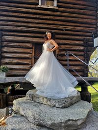 Young woman with umbrella standing against brick wall