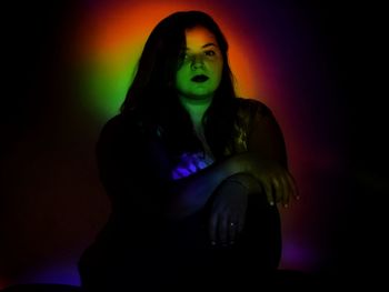 Portrait of woman against black background