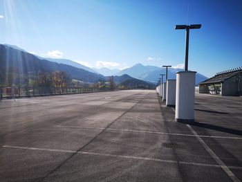 Empty road by mountains against sky