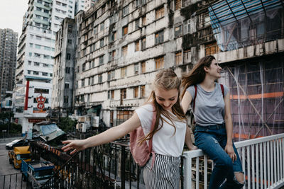 Happy young woman with arms raised in city