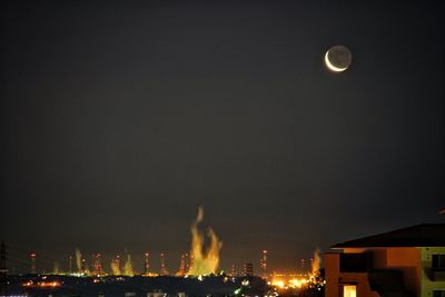 Illuminated buildings against sky at night