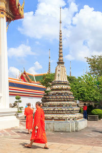 Rear view of people outside temple against building