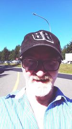 Portrait of man wearing sunglasses against clear blue sky