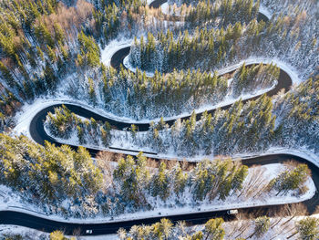 Winding road through the forest, from high mountain pass, in winter time