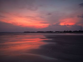 Scenic view of sea against dramatic sky during sunset