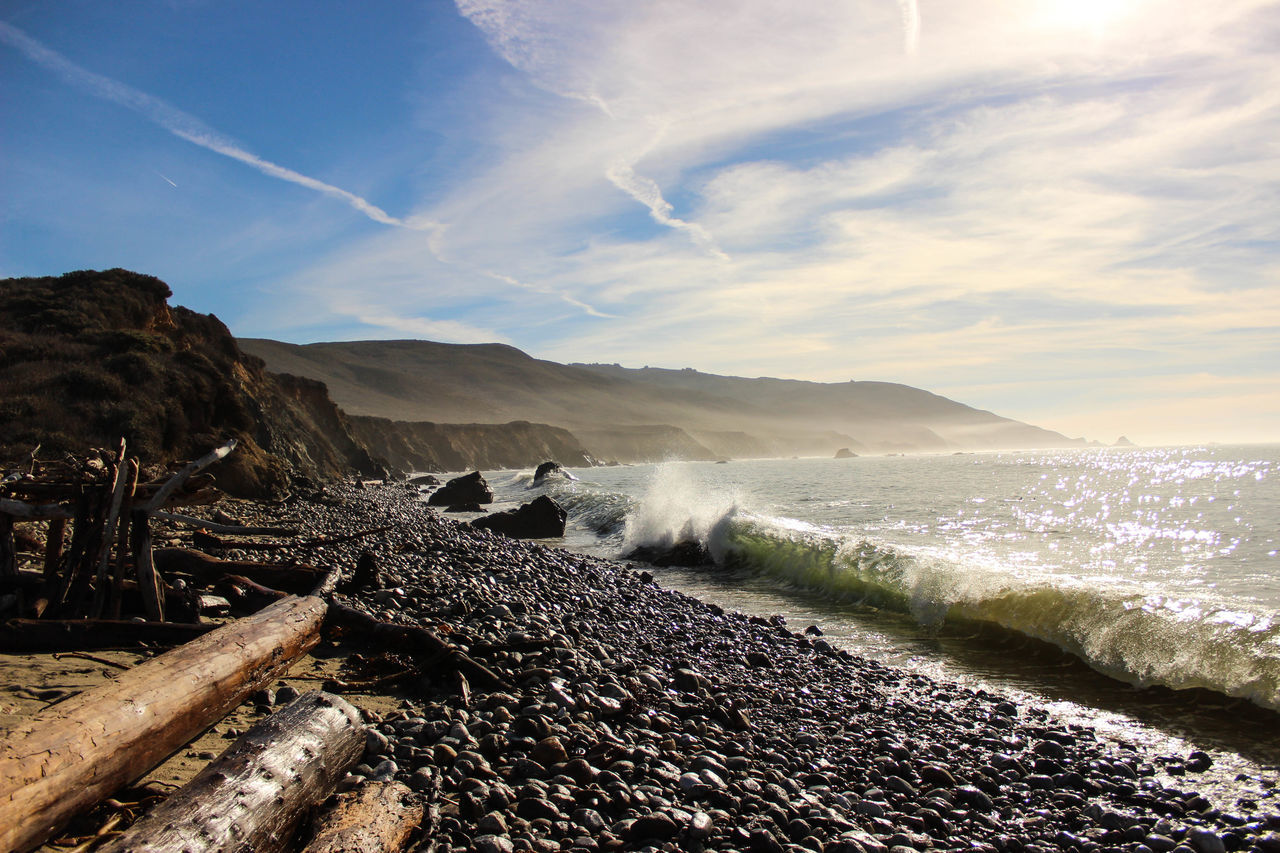 water, sky, scenics, tranquil scene, mountain, beauty in nature, tranquility, nature, beach, cloud - sky, shore, sea, landscape, sand, rock - object, idyllic, non-urban scene, outdoors, day, mountain range