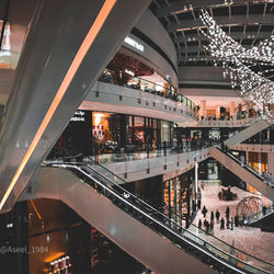 People on illuminated bridge in city