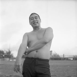 Portrait of shirtless man standing against sky