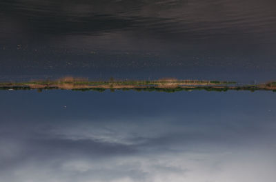 Scenic view of lake against sky at night