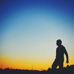 Silhouette of woman against clear sky at sunset