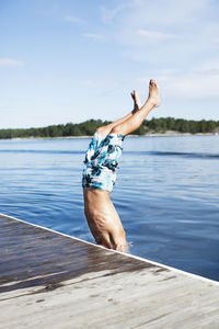 Teenage boy jumping into water