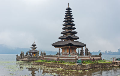 Temple by building against sky