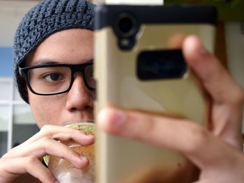 Close-up portrait of teenage boy using mobile phone