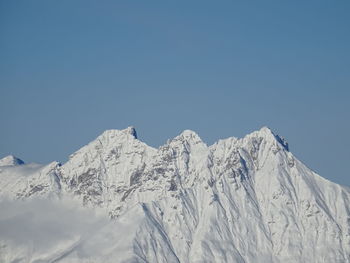 Snowcapped mountains against clear blue sky