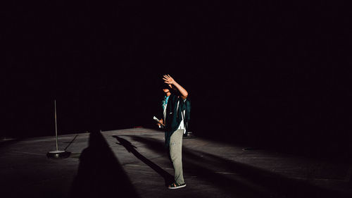 Man with umbrella standing in the dark