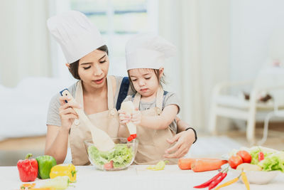 Midsection of woman having food in kitchen