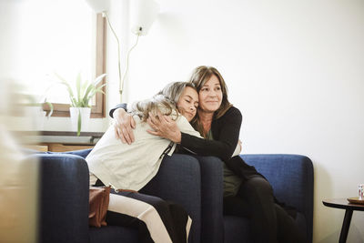 Mother and daughter embracing while sitting at wellness center