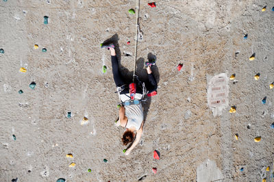 Upside image of woman climbing wall