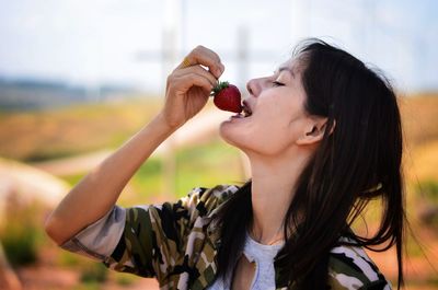 Close-up of woman eating strawberry