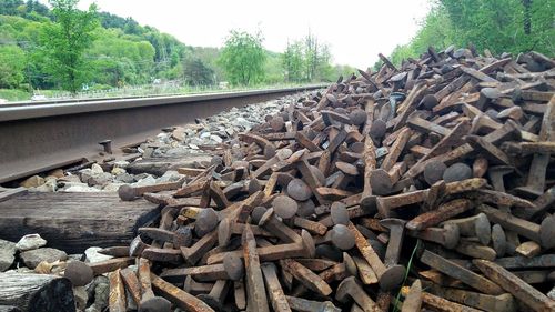 Stack of railroad track by trees in forest